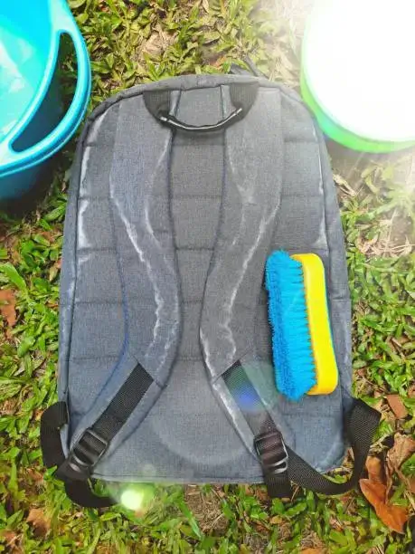 Clean a tactical backpack using brush.