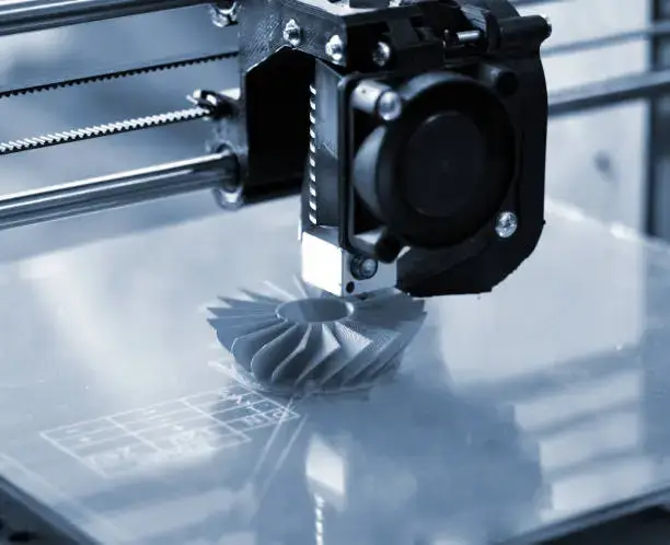 Impresión 3D La impresora 3D imprime formas azules sobre un fondo azul