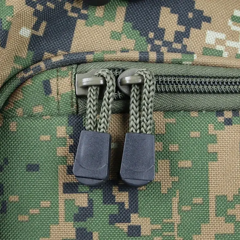 Close-up of camouflage military backpack zipper with braided pulls.