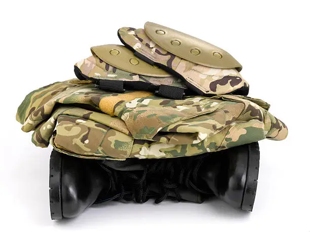 Camouflage uniform stacked on top of black army leather boots.