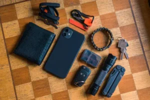 EDC setup. Everyday carry for a man. Knife, Multitool, Flashlight, Car key, Paracord bracelet, Wallet, Zippo, Smartphone